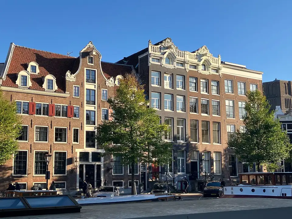 Gabled canal houses along the Singel in Amsterdam under a blue sky