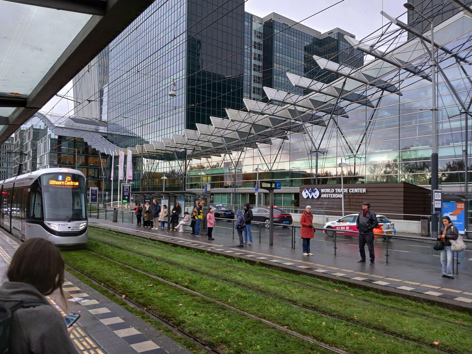 Tram stop by Amsterdam Zuid station with the glass office towers of the Zuidas business district behind it