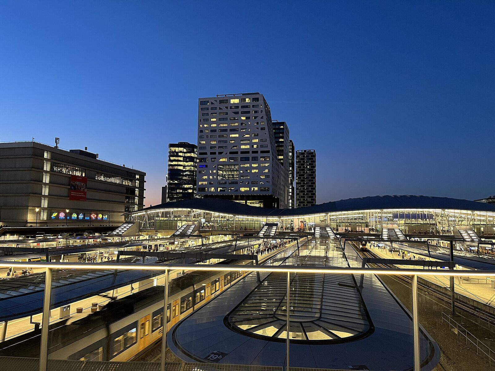 Utrecht Centraal station and the Stadskantoor municipal office at dusk, seen from the Moreelsebrug bridge over the tracks